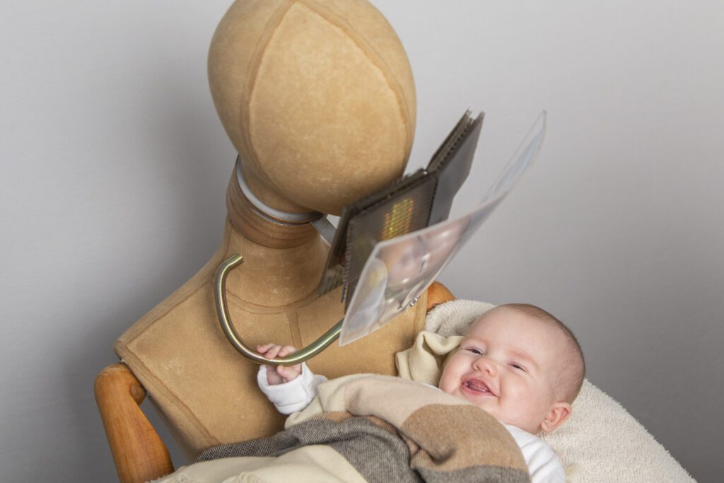 Robotika sosteniendo un bebé real que sonríe en sus brazos